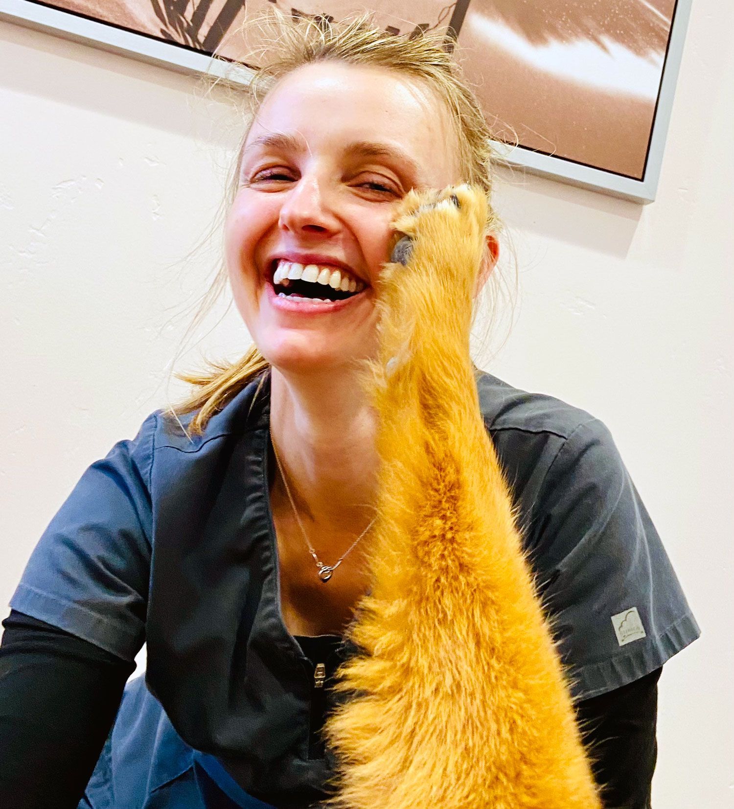 A woman with a cat's paw touching her face