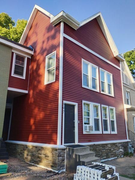 A two-story house with red horizontal siding, white trim.