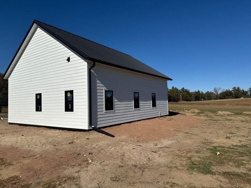 A modern, white rectangular house with a black gabled roof.