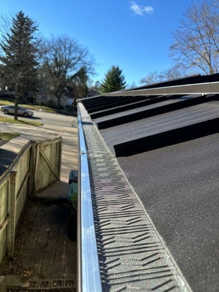 A close-up view of a metal roof edge and a gutter guard.
