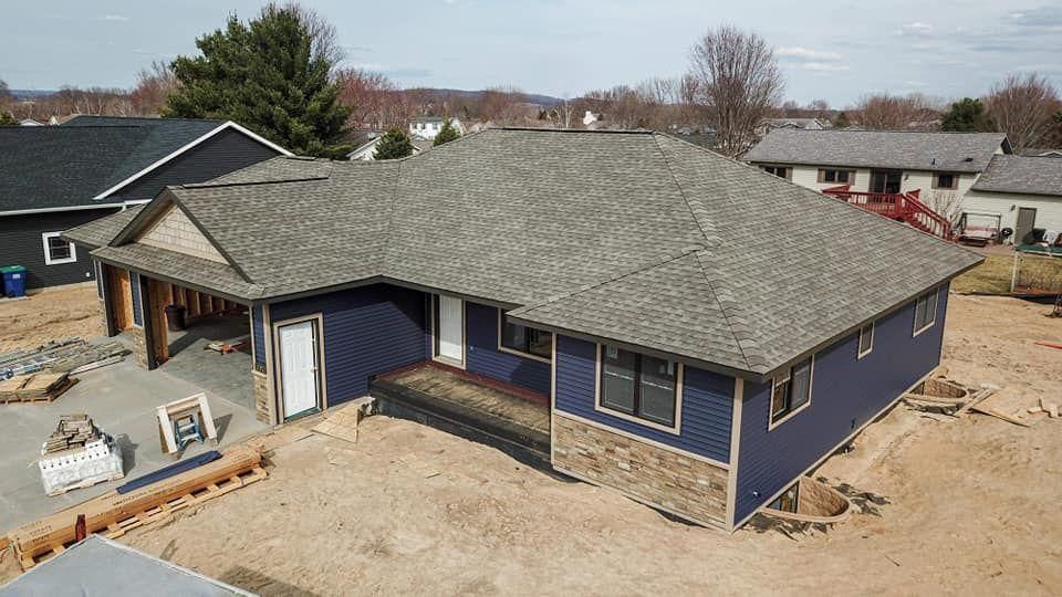 A newly constructed house with blue siding.