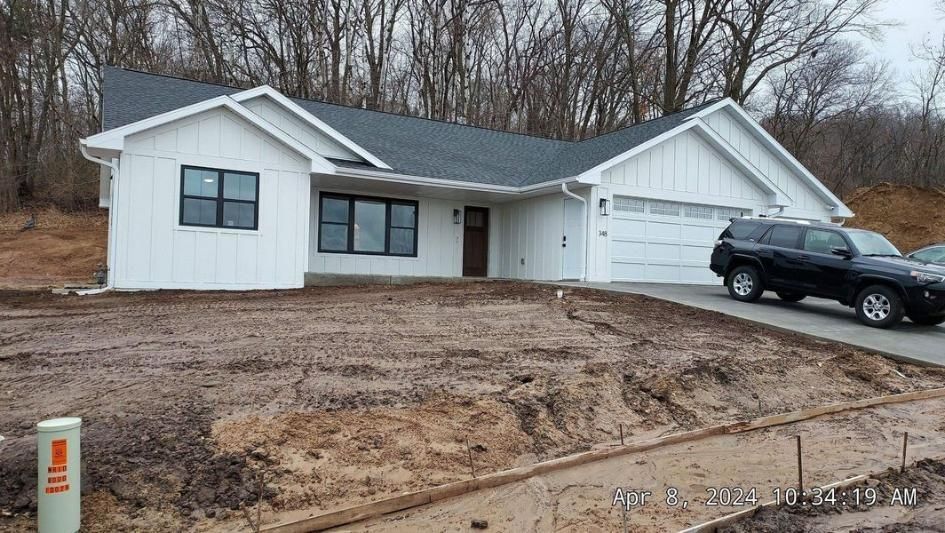 A white ranch-style house with a dark roof and a two-car garage.