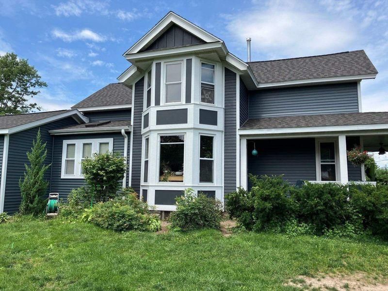 A two-story house with dark blue siding, white trim.