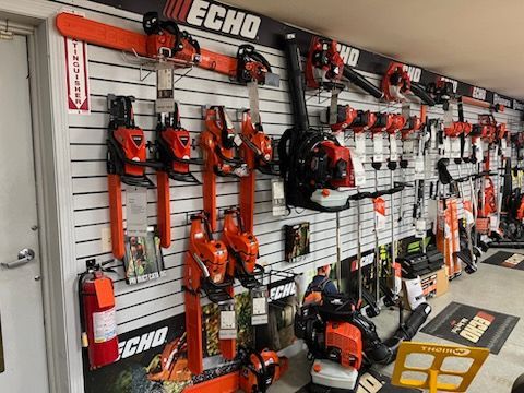 Wall display of orange ECHO power tools and equipment in a store aisle