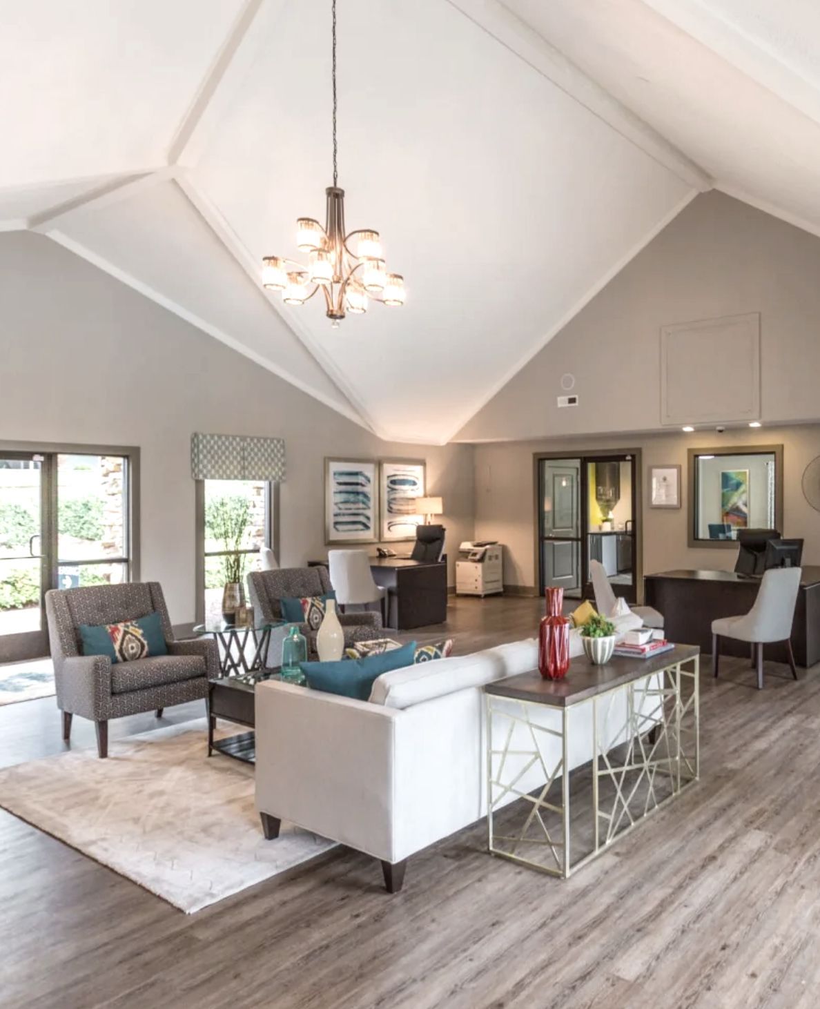 Modern reception area with a high, angled ceiling, seating area, and front desk.