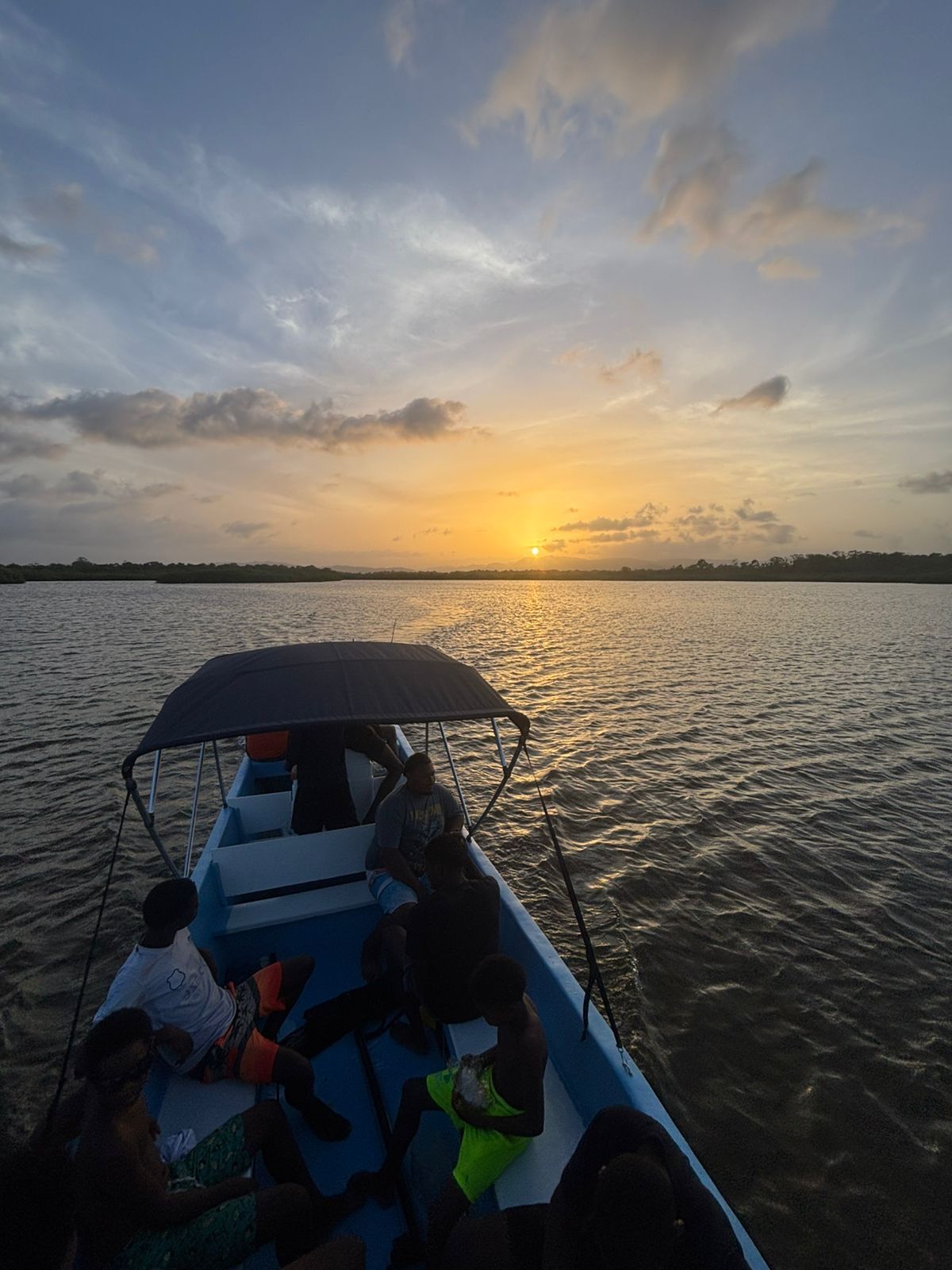 Tour boat on calm Caribbean water at golden hour