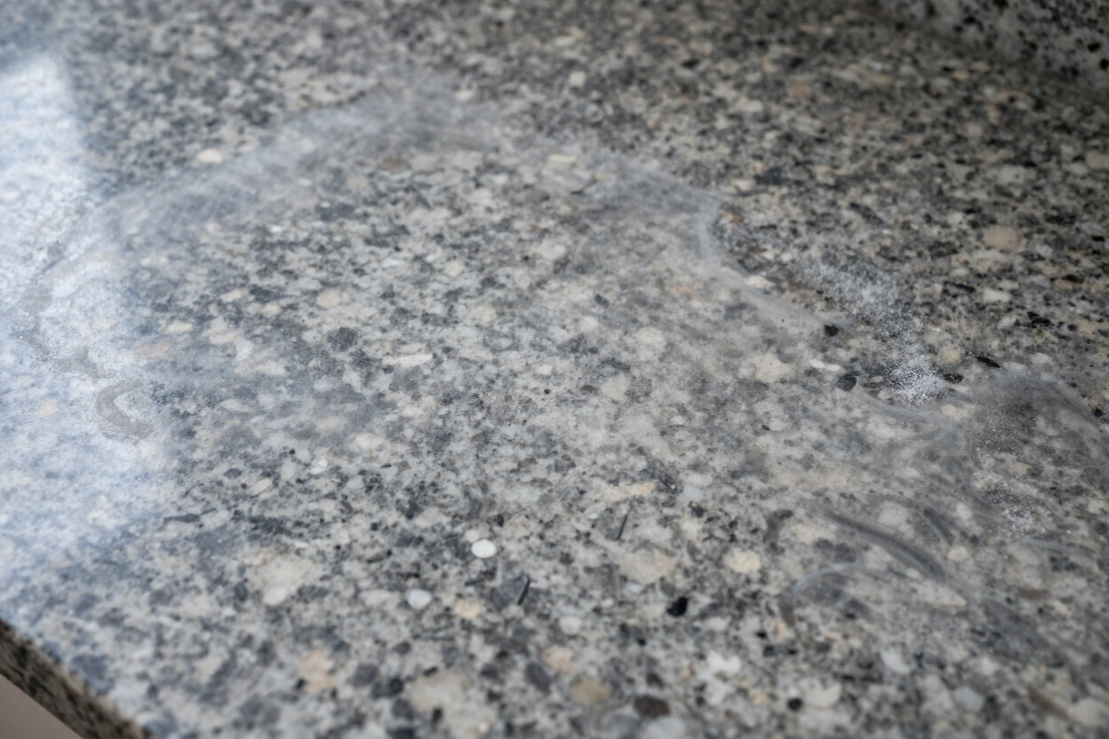 Hazy film buildup on a granite countertop
