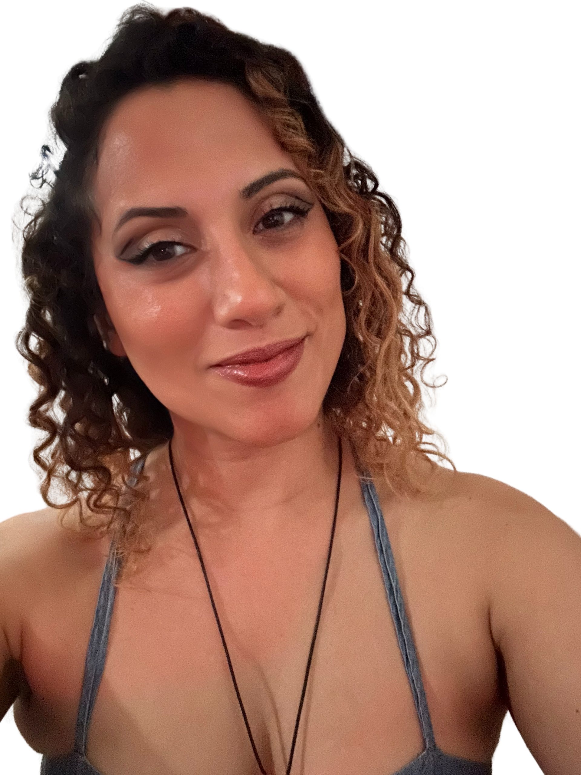 Woman with curly brown hair smiling, wearing a blue halter top, against a white backdrop.
