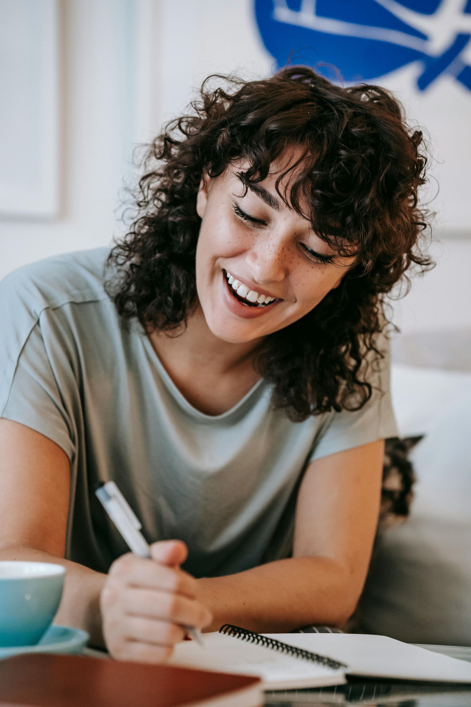 A lady smiling while writing - Meditating on Scripture through Bible Memorization