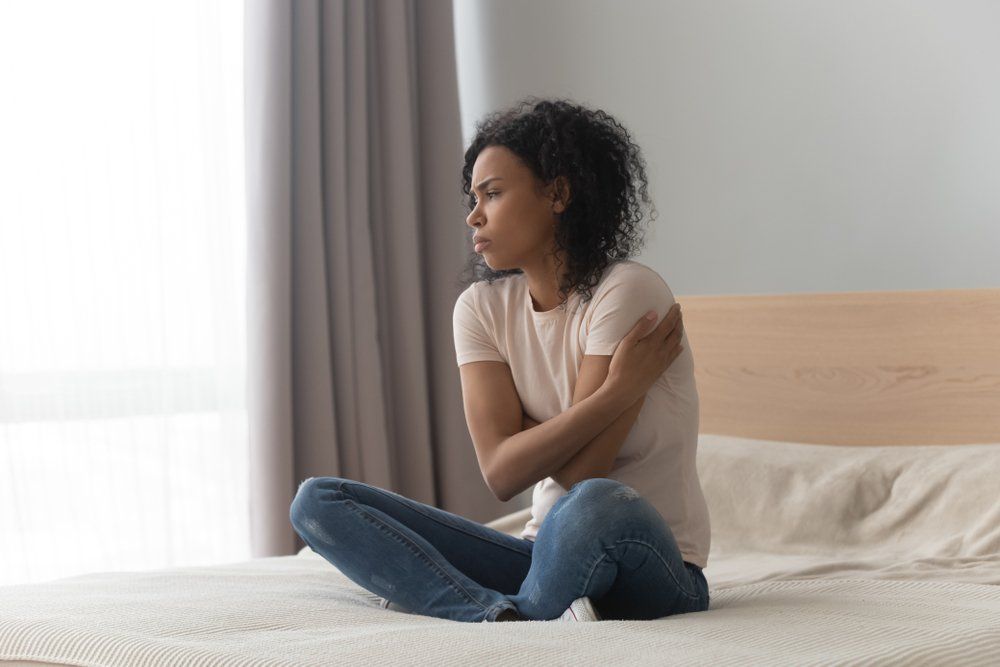 Sad tired young woman touching forehead having headache migraine or depression