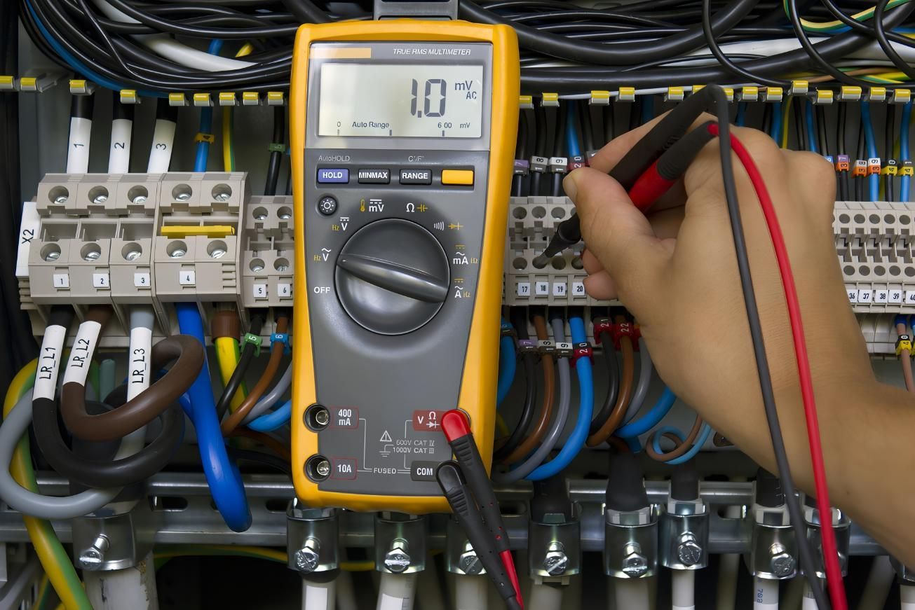 Person Using a Multimeter to Test Wires in an Electrical Panel — AES Electrical Contracting In Howard Springs, NT