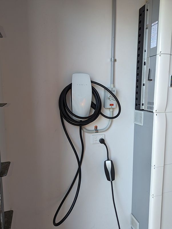 A Tesla Charging Station is Attached to a Wall — AES Electrical Contracting In Winnellie, NT