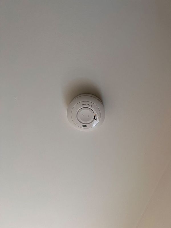 A Smoke Detector is Hanging From the Ceiling of a Room — AES Electrical Contracting In Winnellie, NT