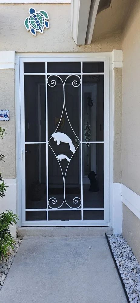White security door with decorative metalwork at a house entrance