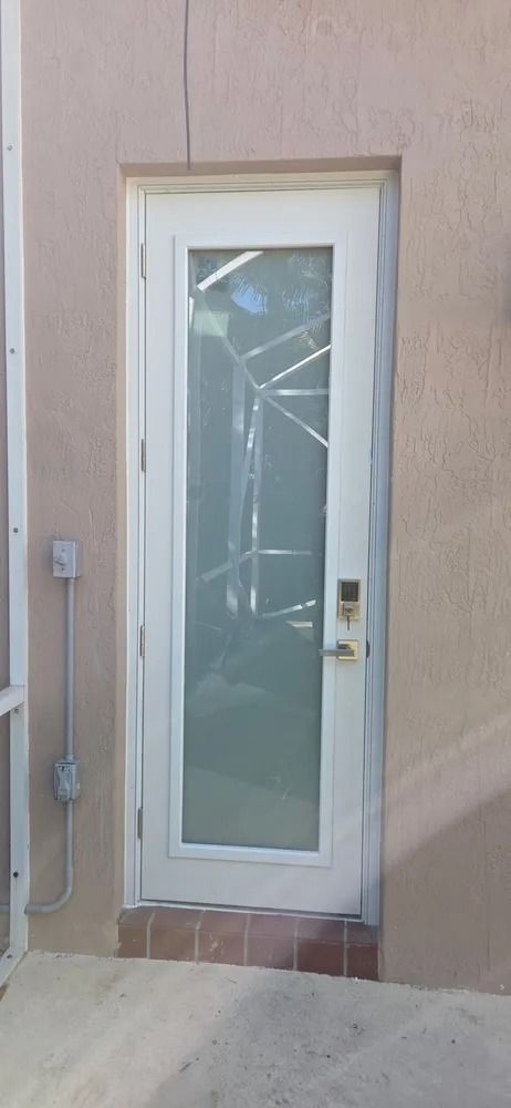 Front door with frosted glass panel and beige stucco wall