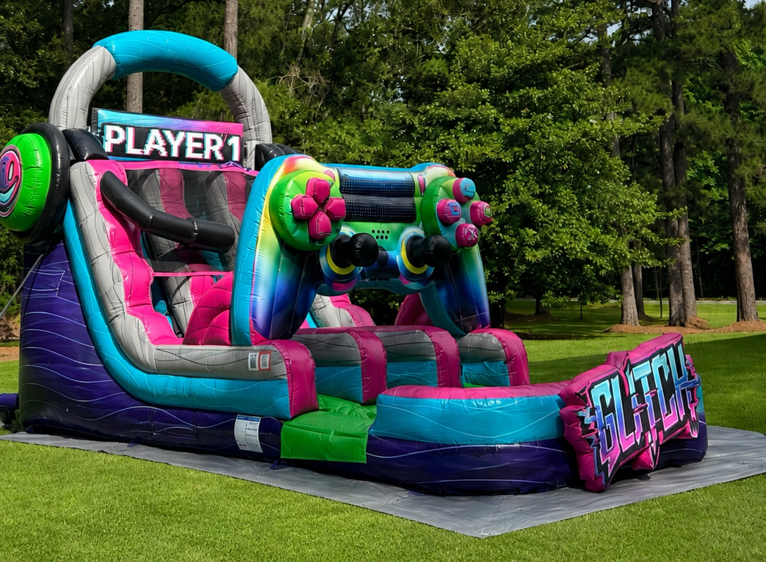 Colorful inflatable obstacle course with “PLAYER1” on a lawn in a park, featuring neon pink, blue, and green accents