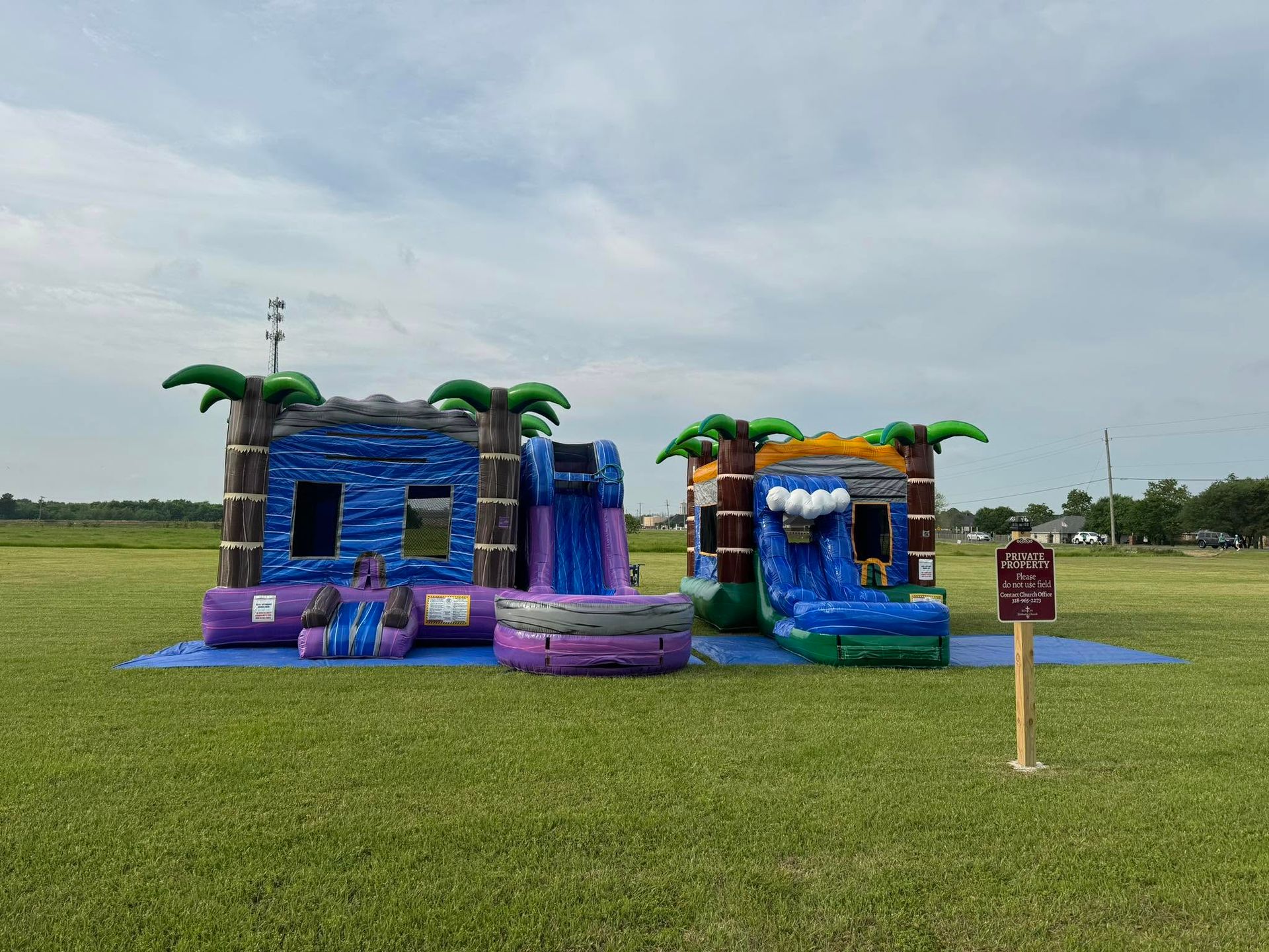 Colorful inflatable water play structure on a grassy field under a cloudy sky