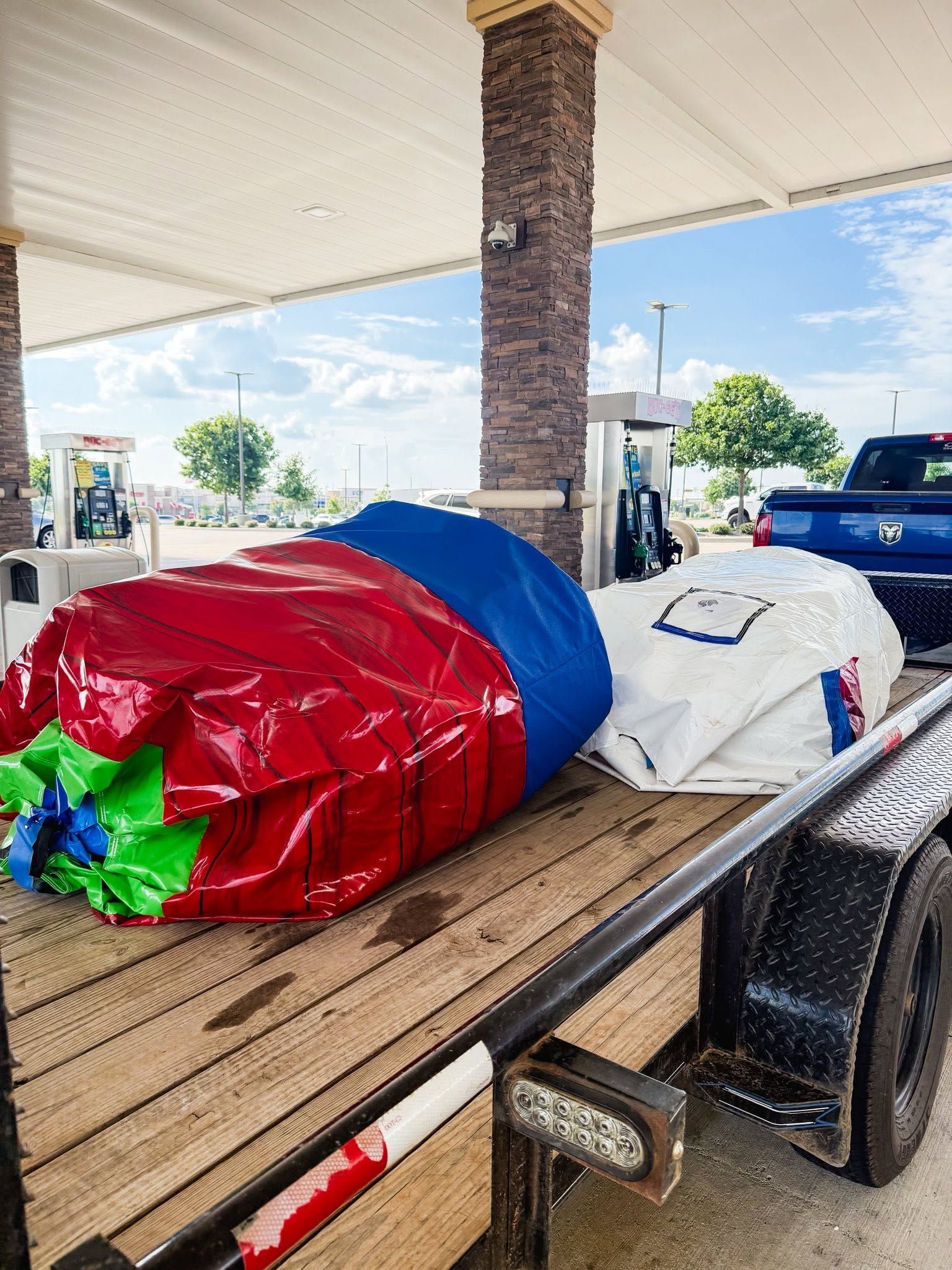 Wrapped furniture on a trailer under a gas station canopy