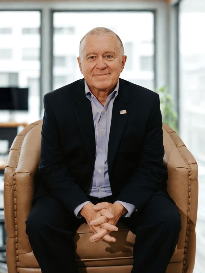 A man in a suit and tie is smiling for the camera