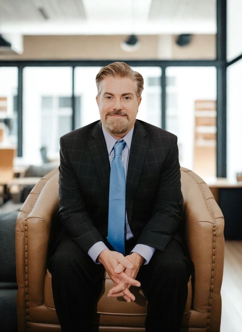 A man with a beard is wearing a suit and tie.