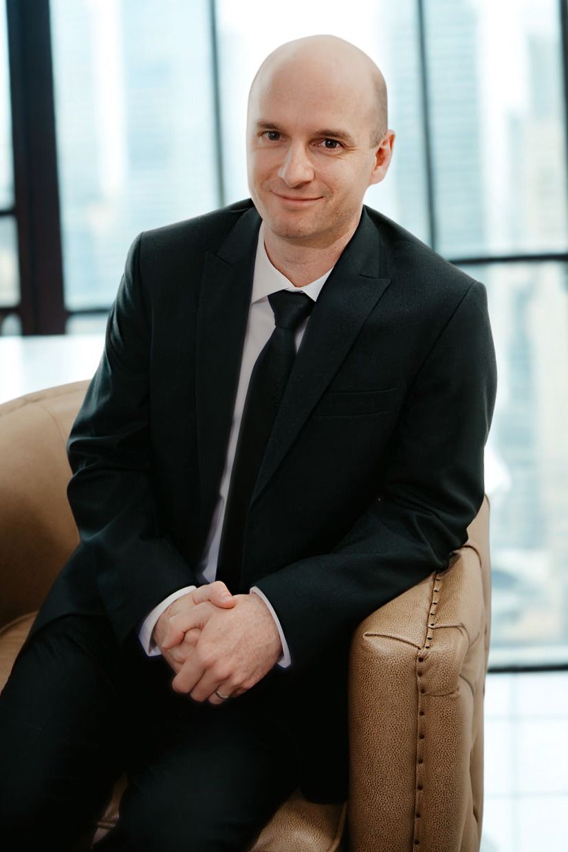 A man in a suit and tie is smiling for the camera