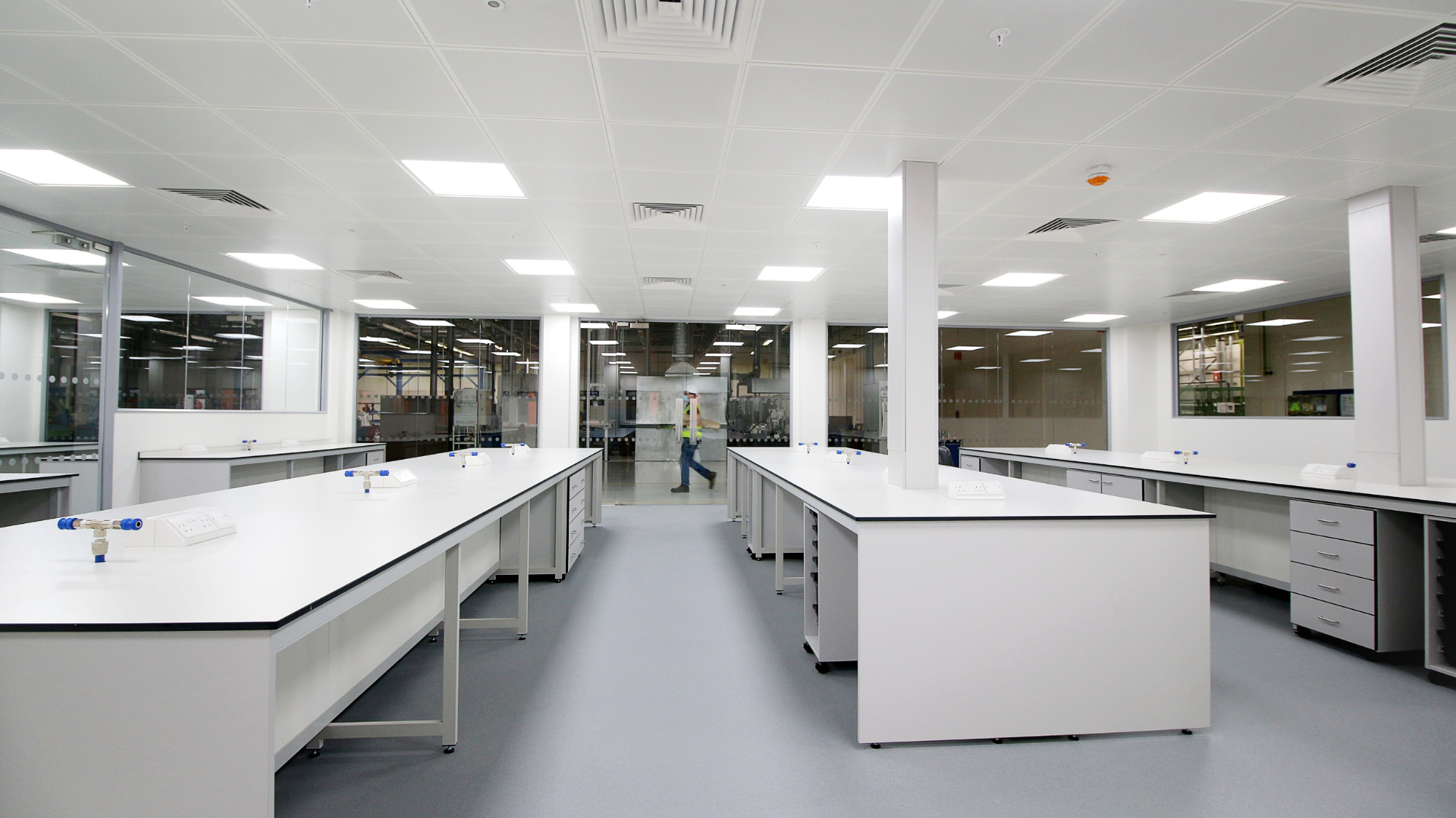 Bright modern laboratory with white workbenches, cabinets, and overhead fluorescent lighting
