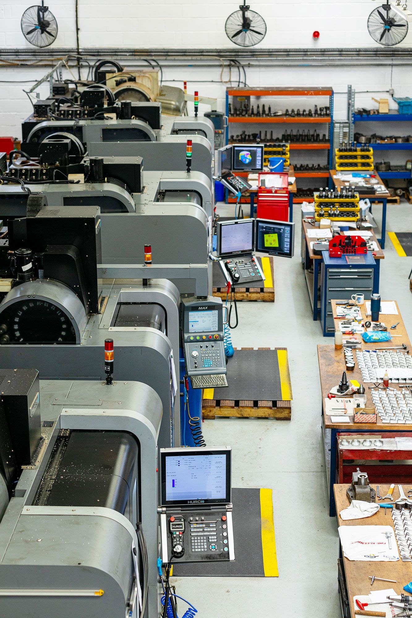 Factory floor with rows of industrial machines and workstations in a bright production facility