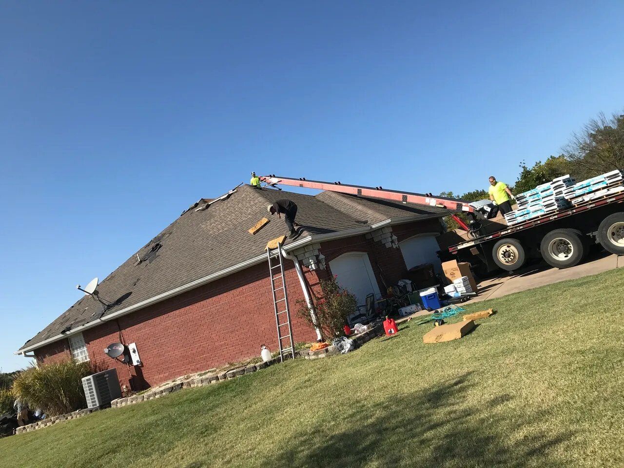 A large truck is parked in front of a brick house.