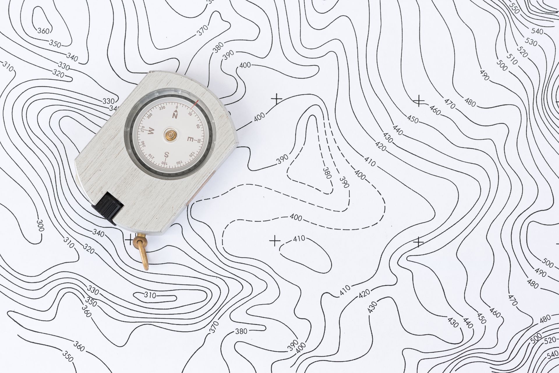 A compass is sitting on top of a topographic map.