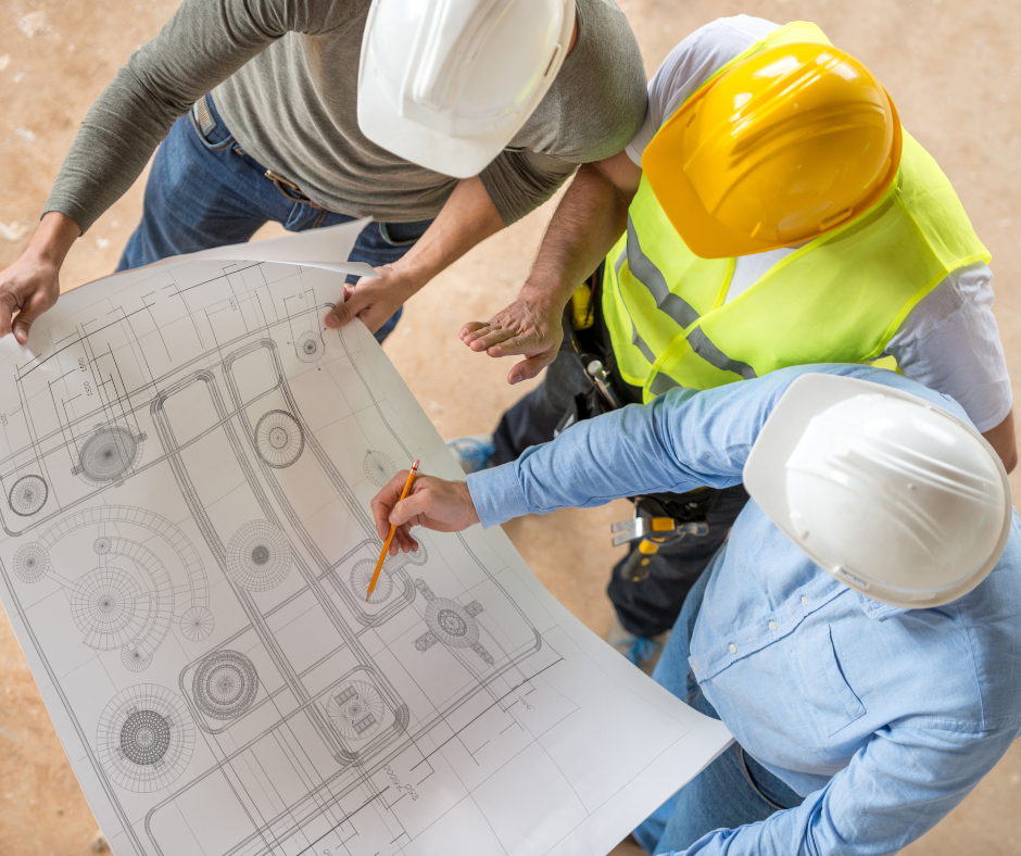 A group of construction workers are looking at a blueprint to make engineering decisions.