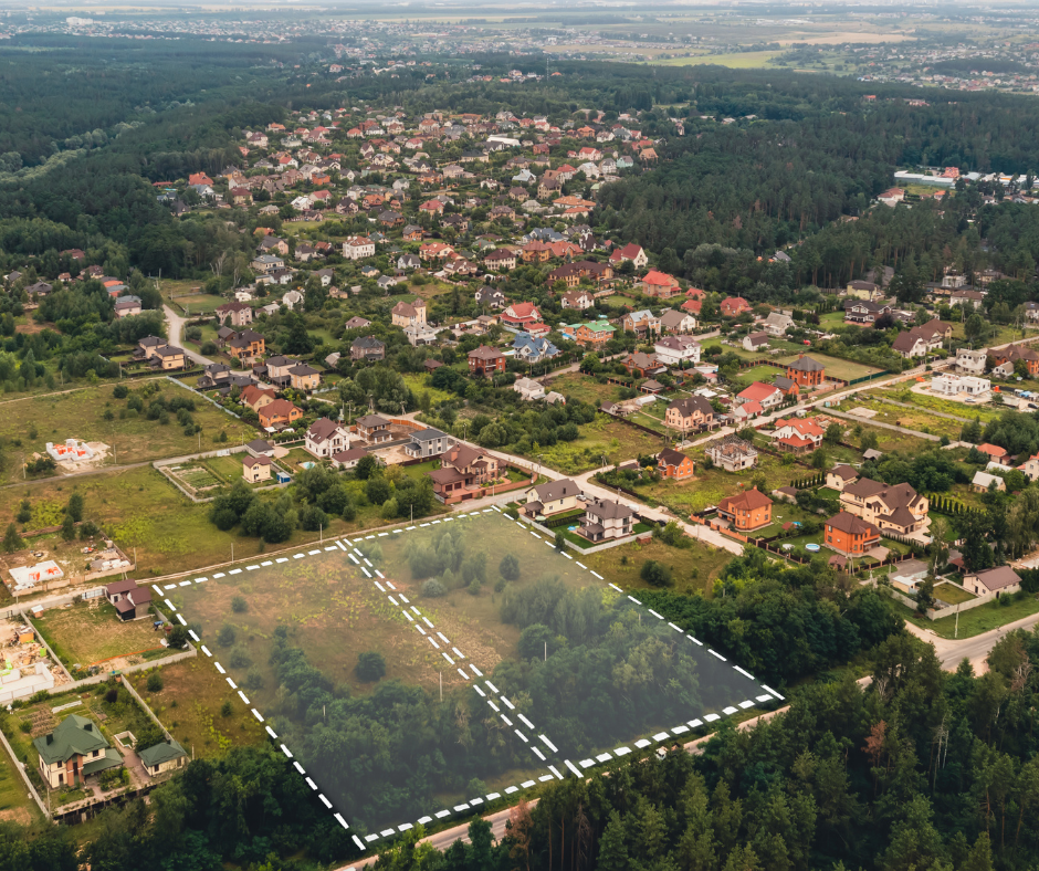 An aerial view of a residential area with a lot of houses and trees with a white square mapped out for a land survey