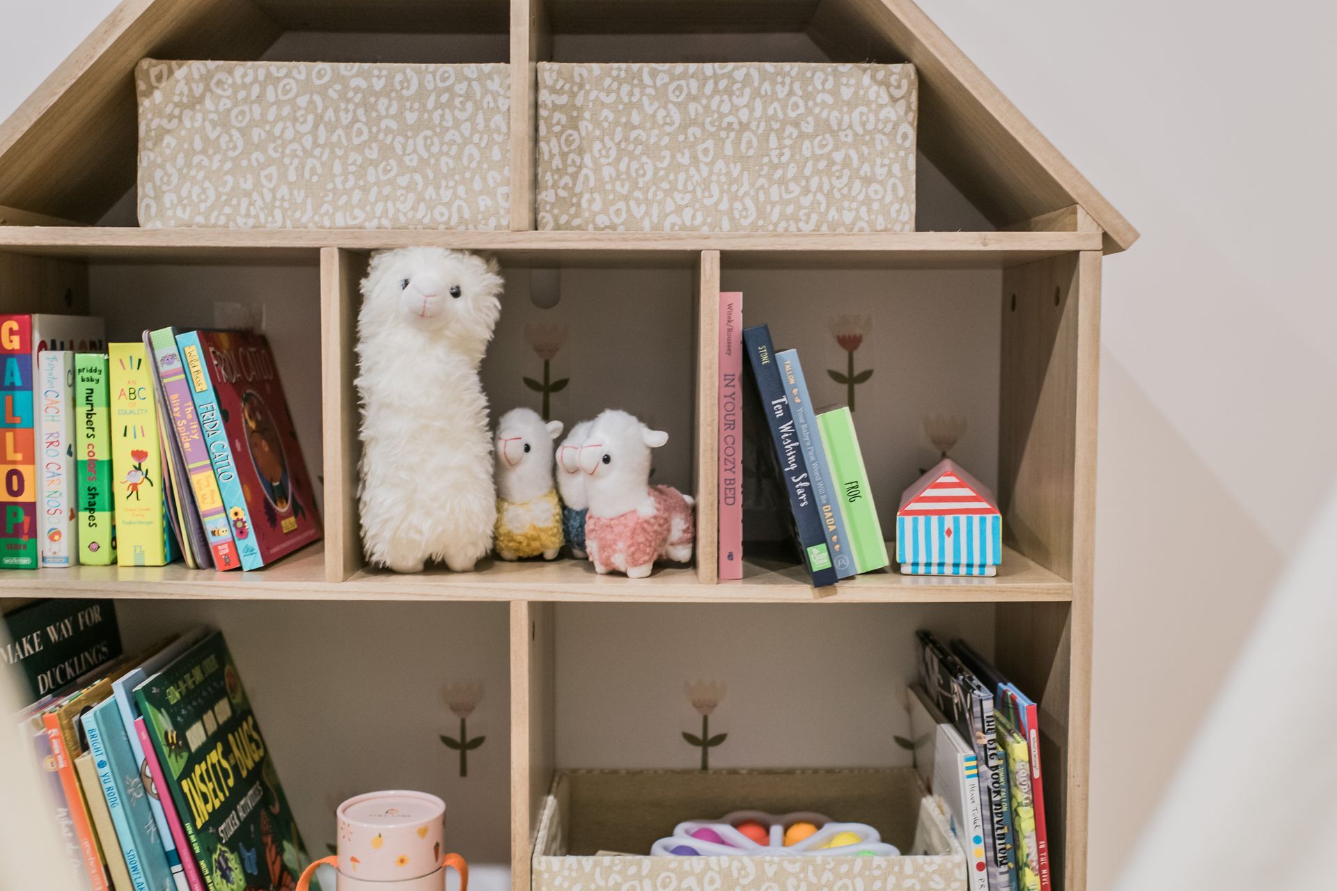 A children's bookshelf with toys and books