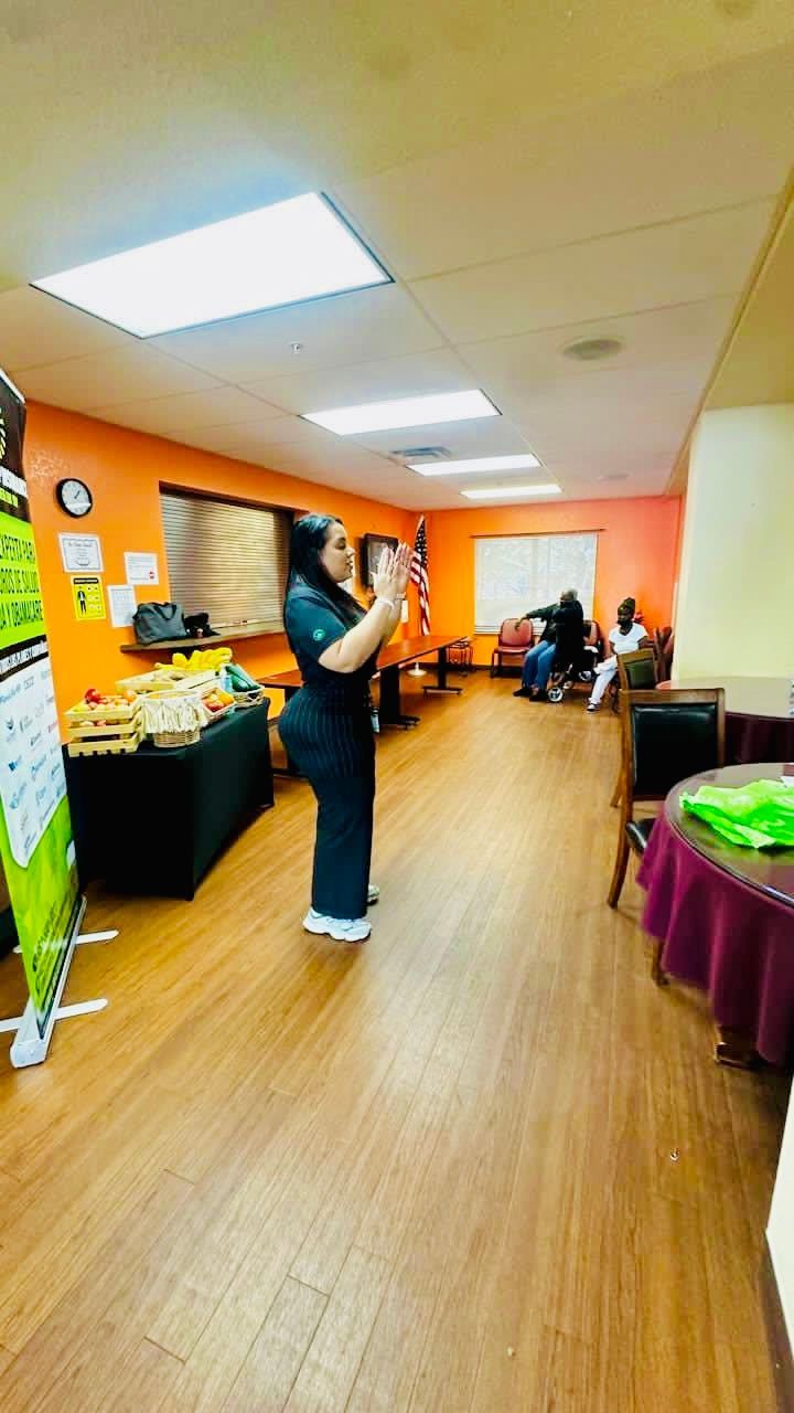 A woman is standing in a room taking a picture with her phone.