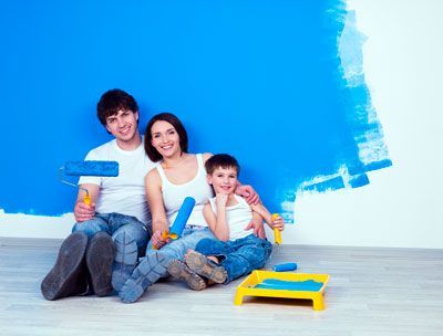 Una familia está sentada en el suelo frente a una pared azul.