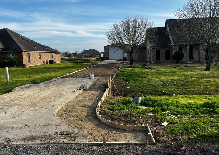 A dirt road leading to a house in a residential area.