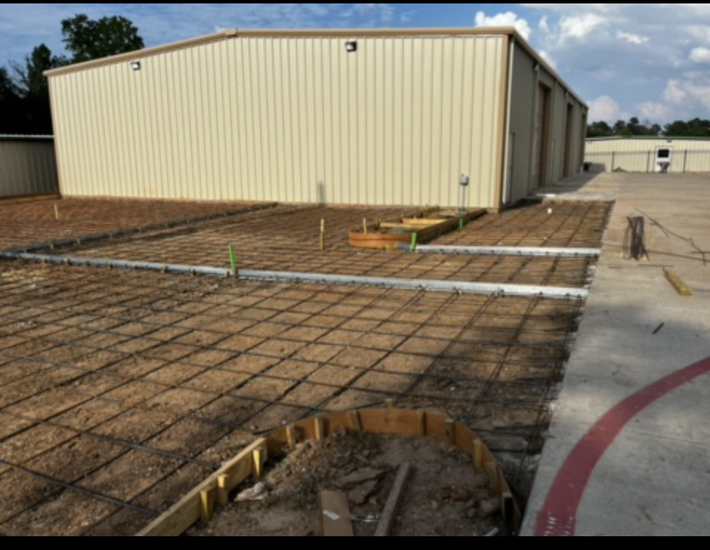 A concrete driveway is being built in front of a building