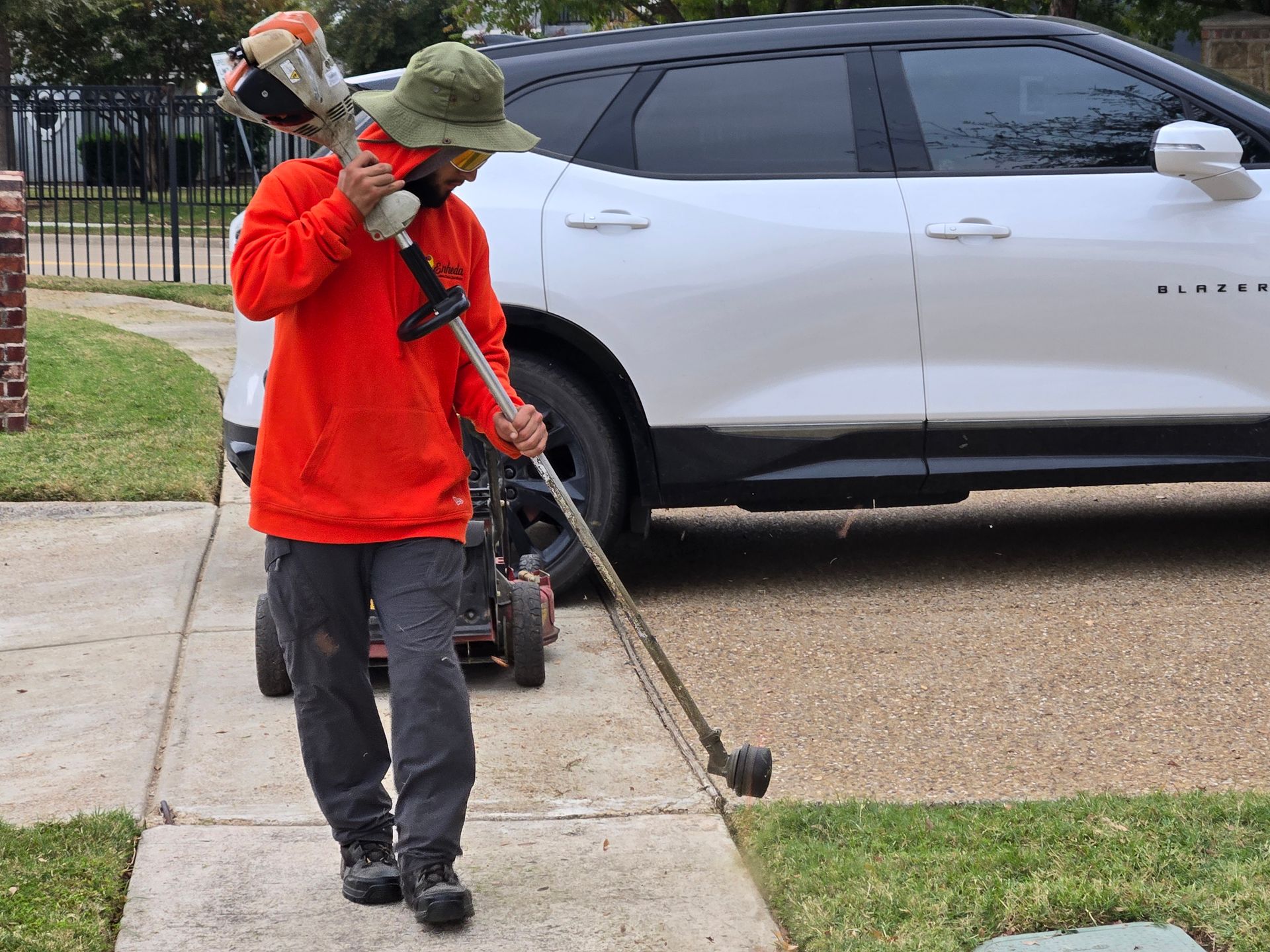 A man weed eating a lawn.
