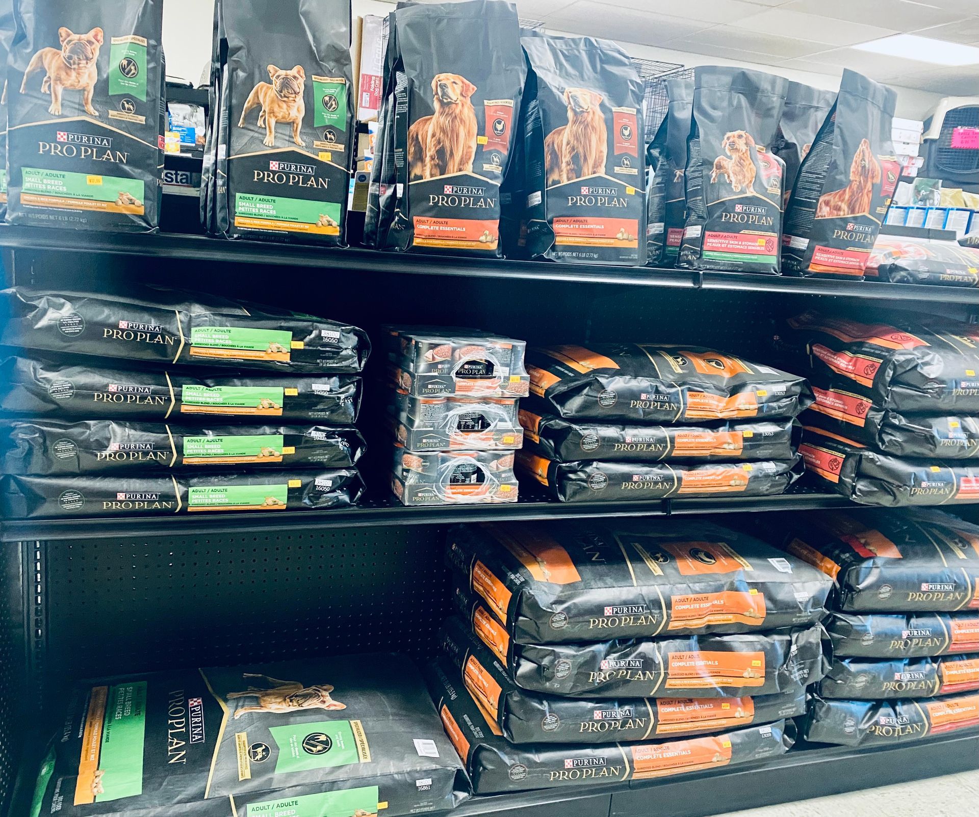 Shelves of stacked pet food bags in a store aisle