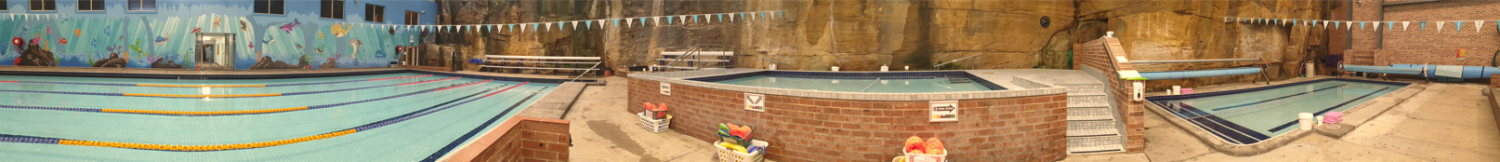 Indoor pool area with several pools, brown stone walls, and warm lighting.