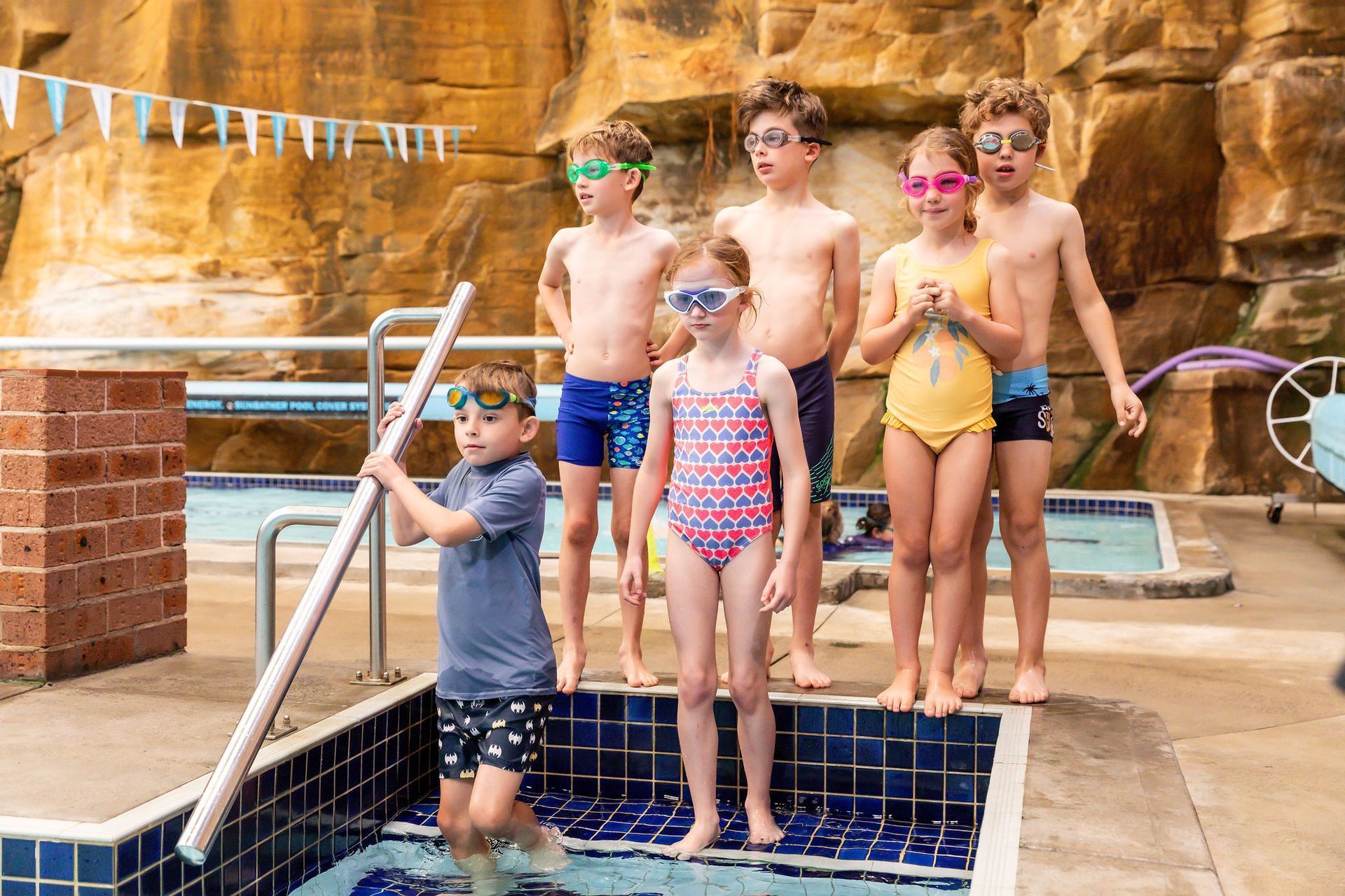 child learning water safety education through swimming lessons