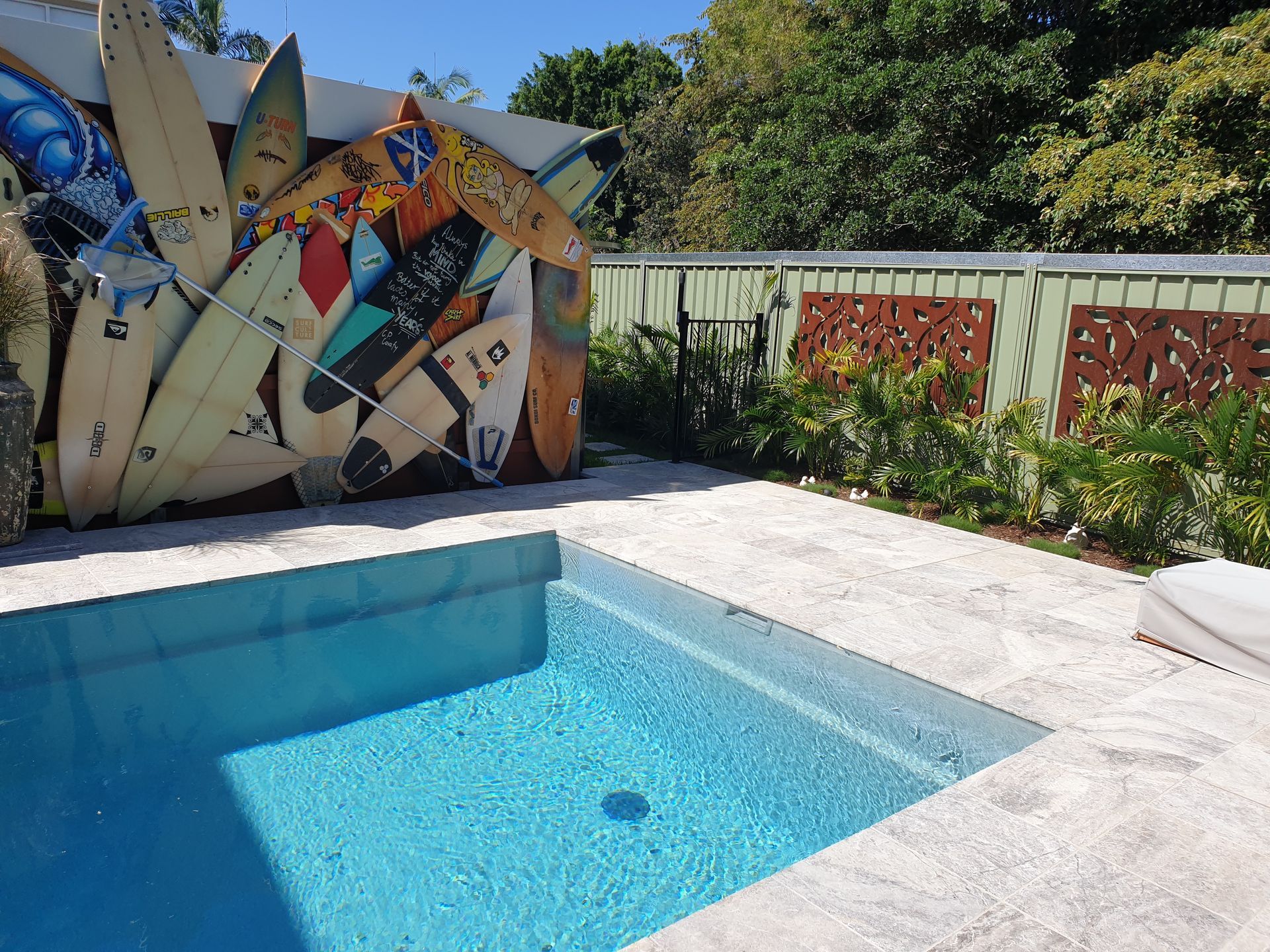 A swimming pool has a large piece of art behind it — Tim Williams Landscapes in Wollongbar, NSW