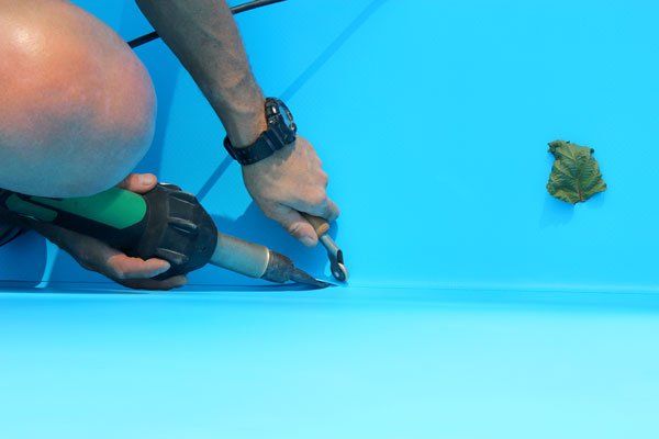 Pool repair technician diagnosing pump issue in The Woodlands, TX