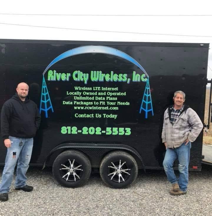 Two men stand by a trailer with 
