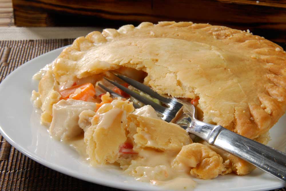 A hot chicken pot pie broken open with a fork