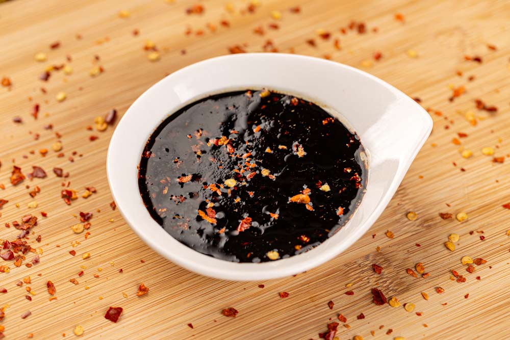 Bowl of teriyaki sauce, traditional Japanese sauce on bamboo board