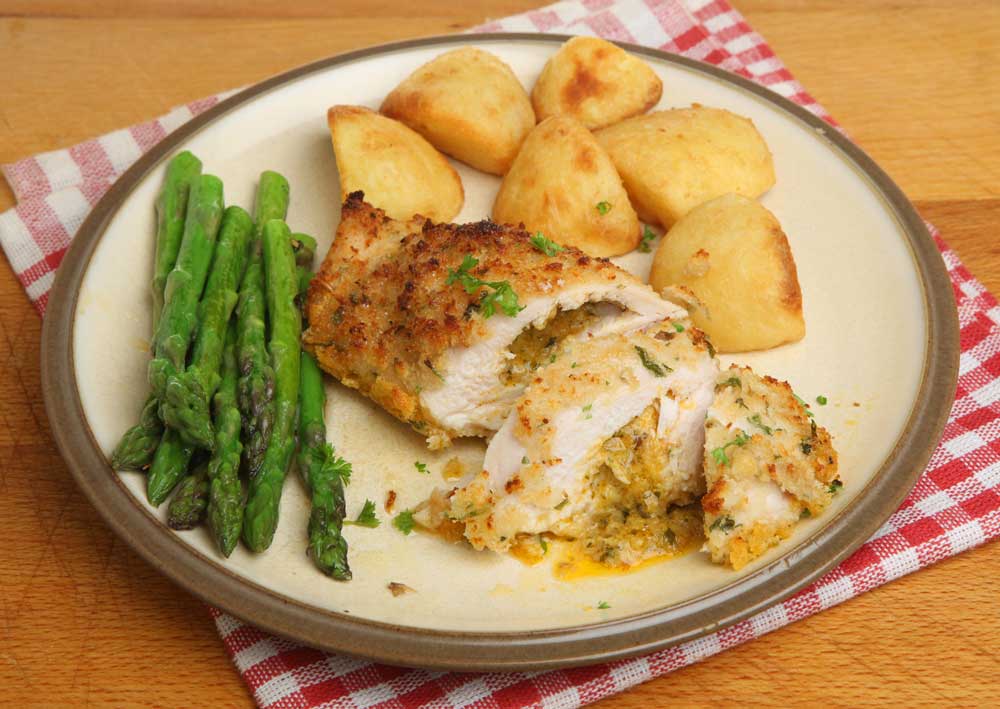Chicken Kiev, stuffed with garlic and herb butter, served with potatoes and asparagus