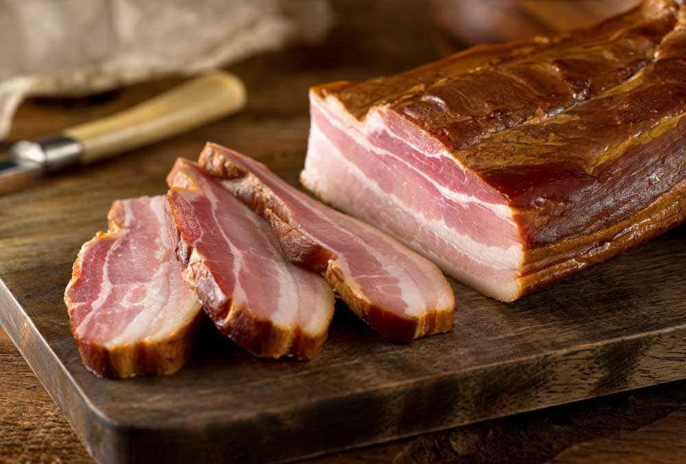 Homemade smoked bacon on wooden board