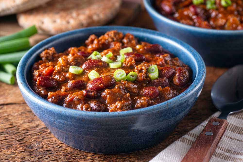 Delicious homemade beef chili con carne with green onion garnish