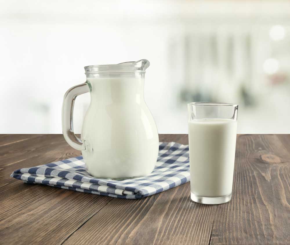 Milk glass container and cup of milk