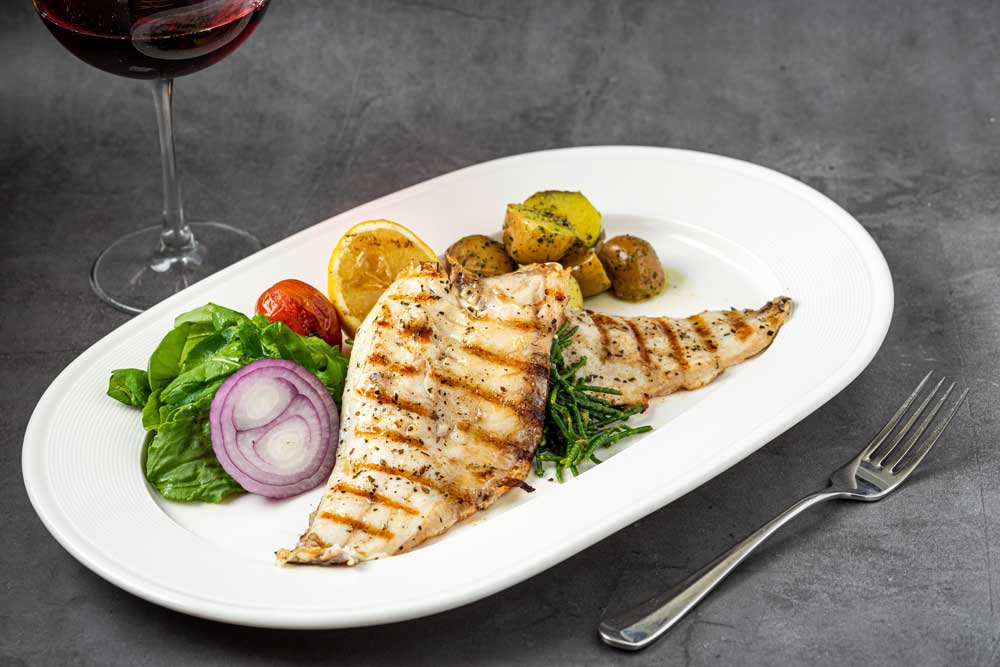 Grilled seabass fillet with garnish, seafood fish dish